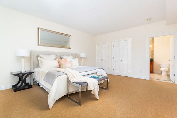 Master bedroom with tan carpet leading to bathroom. Click to view the photo gallery.
