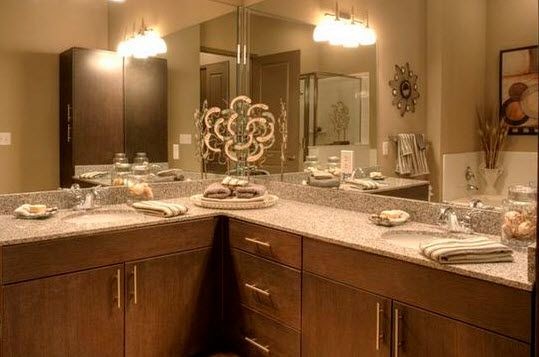 apartment bathroom with corner countertops and large mirrors