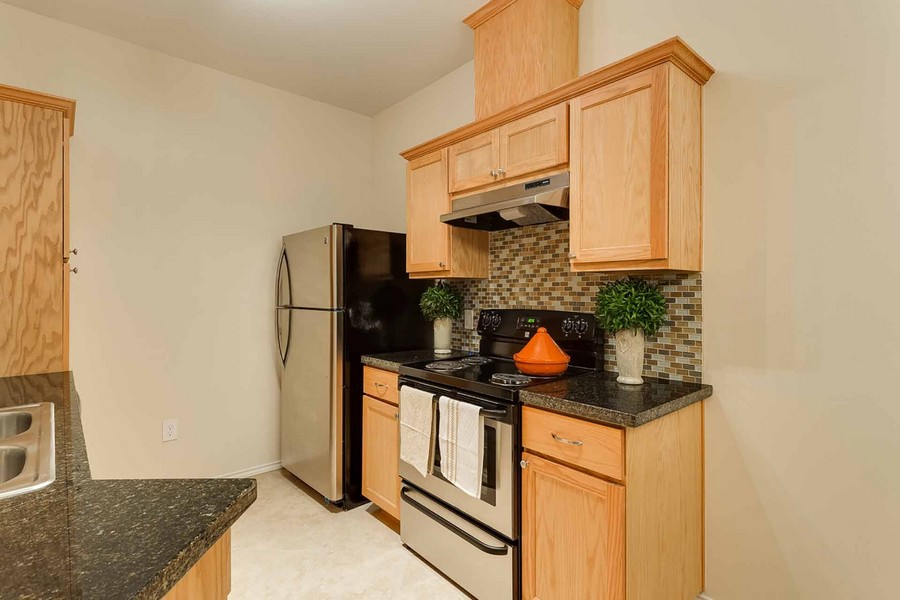 Apartment kitchen with silver appliances and granite countertops