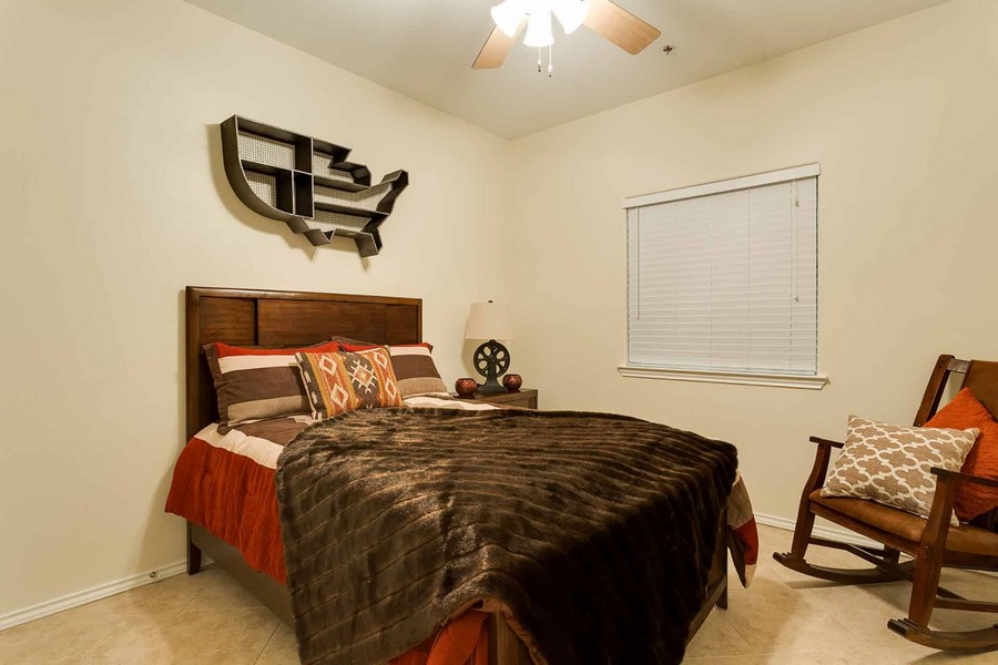 Apartment bedroom with ceiling fan and tile floor