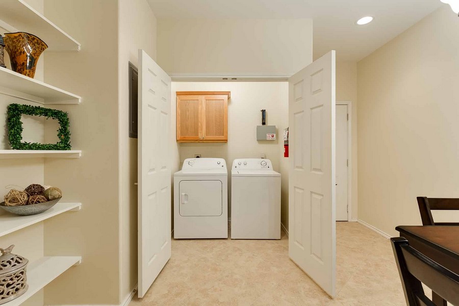Doors near dining area opening to reveal laundry area