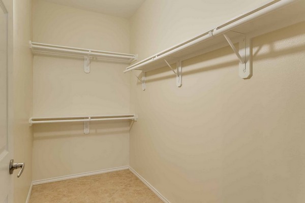 Large empty walk-in closet with shelves and racks for hangers. Click to view the photo gallery.