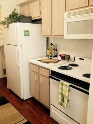 Apartment kitchen with light color cabinets and a refrigerator. . Click to view the photo gallery.