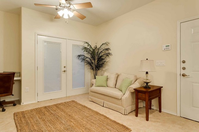 living room with sturdy double doors, ceiling fan, and furniture