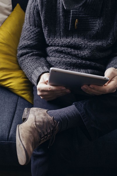 Person sitting on couch with tablet